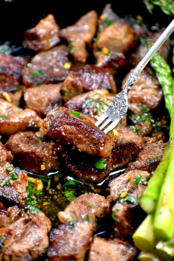 用叉子夹起一块嫩牛肉。