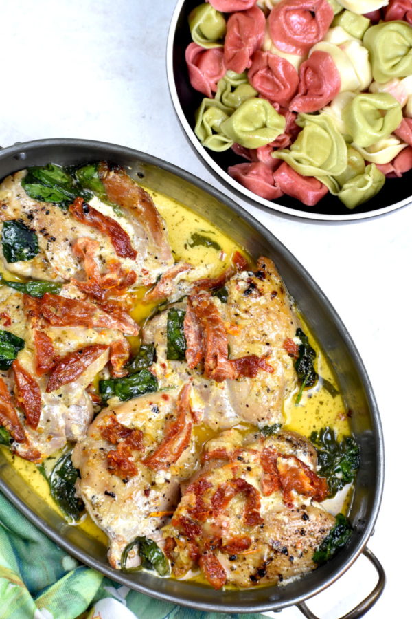金属碗托斯卡纳鸡肉旁边是三色意大利饺子。