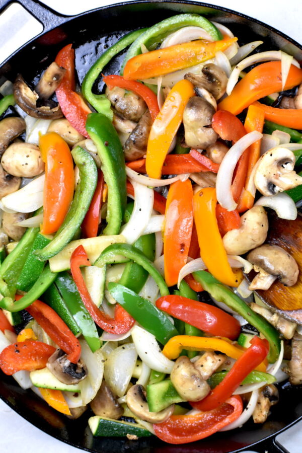蔬菜sautéing在铸铁煎锅里。