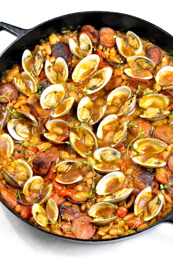 这些西班牙蛤蜊是用炖豆，西班牙香肠和很棒的调味剂一起炖的。这是一种非常棒的小吃，非常适合客人或特殊场合!