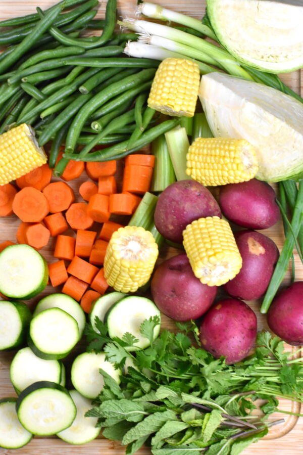 一堆不同的蔬菜放在砧板上。