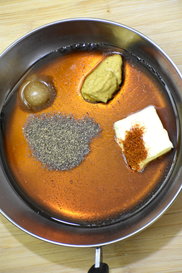 将枫糖浆、黄油、盐、胡椒粉、辣椒粉和棕色芥末酱放入一个小金属锅中