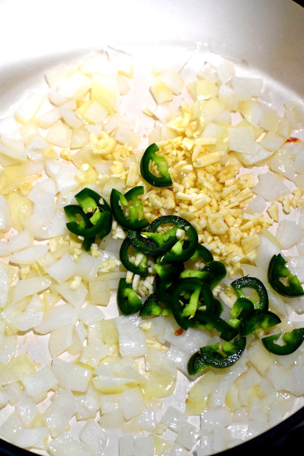 将洋葱、大蒜和墨西哥辣椒丁放入荷兰烤箱中油炸