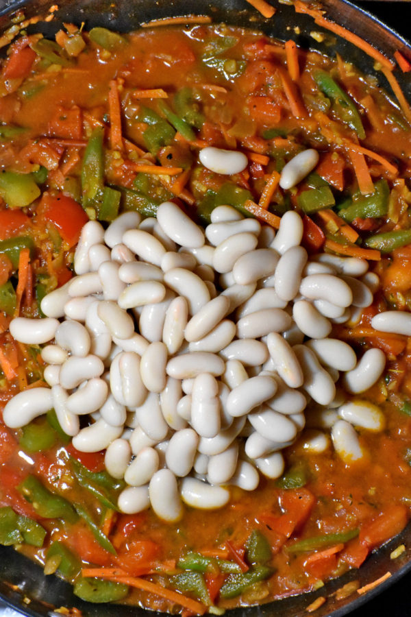 加在煮熟的蔬菜混合物里的Cannellini豆子。