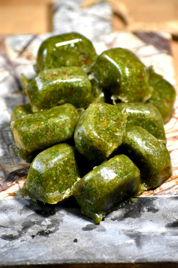 一堆冻在石头砧板上的绿色调味块。