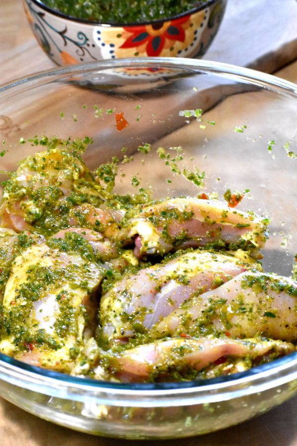 鸡肉块用绿色调味料腌制。