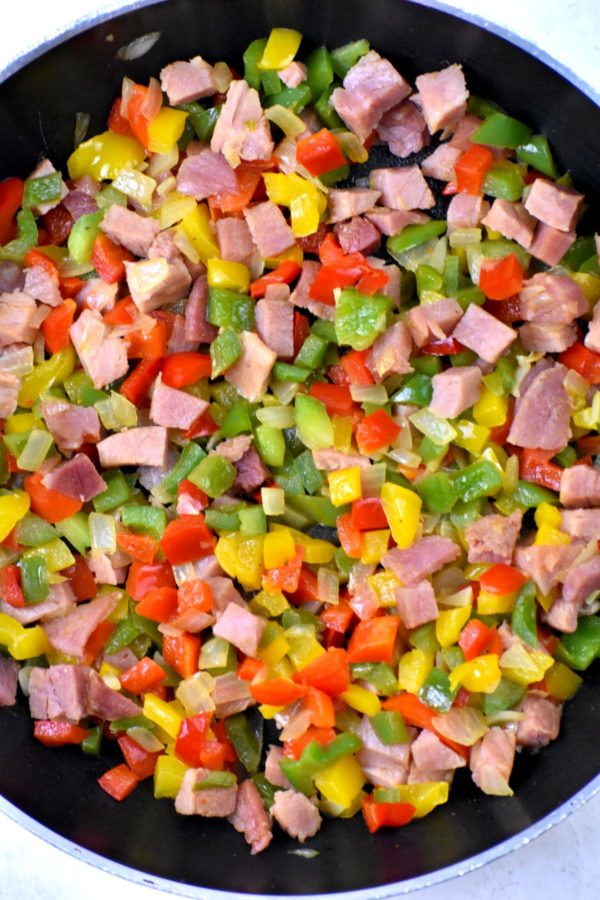 火腿丁，洋葱和彩色灯笼椒在煎锅里。