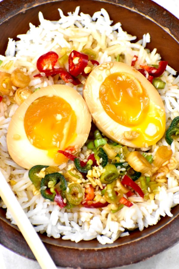 一碗米饭，上面放两个半蛋和一些腌料。