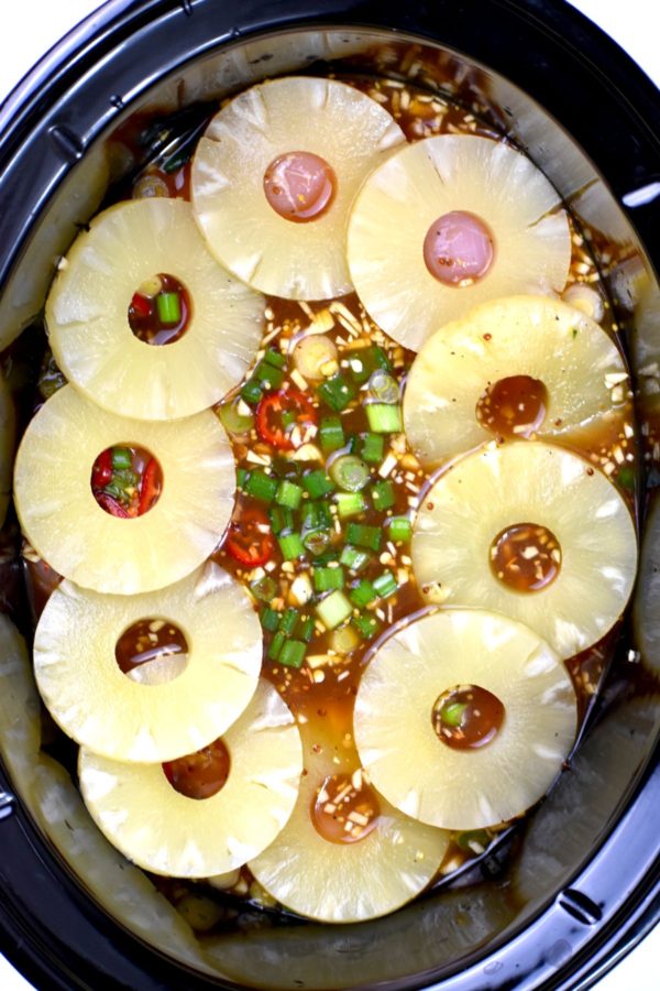 菠萝圈放在鸡肉上，酱汁放在炖锅里。