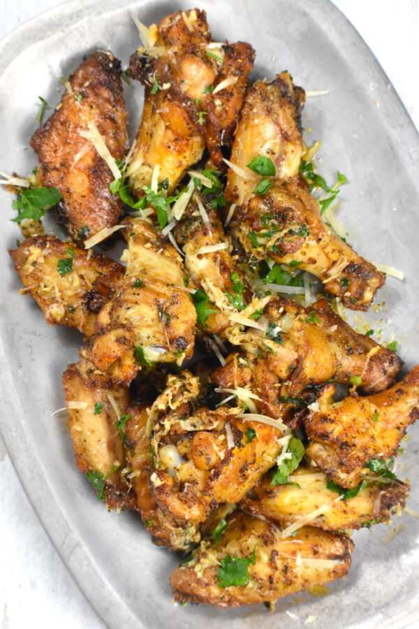 这些蒜味帕玛森鸡翅可以打败任何餐馆的鸡翅，而且非常简单。把它们放在烤箱或空气炸锅里煮，都很好吃!