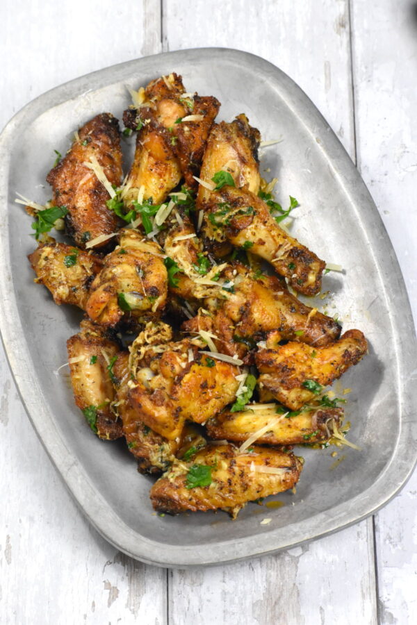 这些蒜味帕玛森鸡翅可以打败任何餐馆的鸡翅，而且非常简单。把它们放在烤箱或空气炸锅里煮，都很好吃!