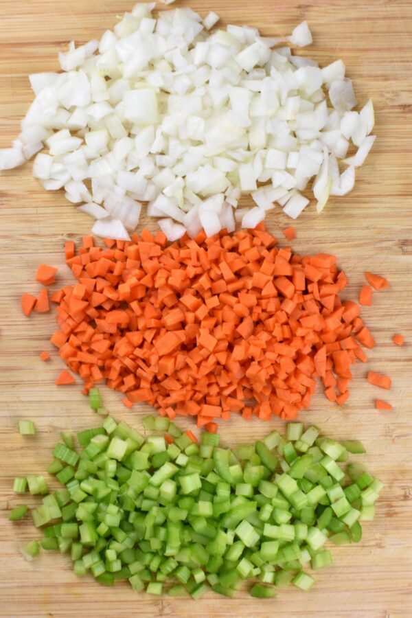 切好的洋葱、胡萝卜和芹菜放在砧板上